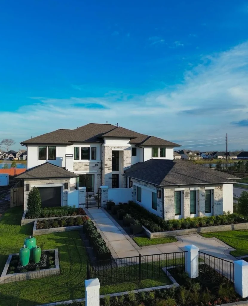 Luxury dream home exterior with stone and stucco facade and gated entry.