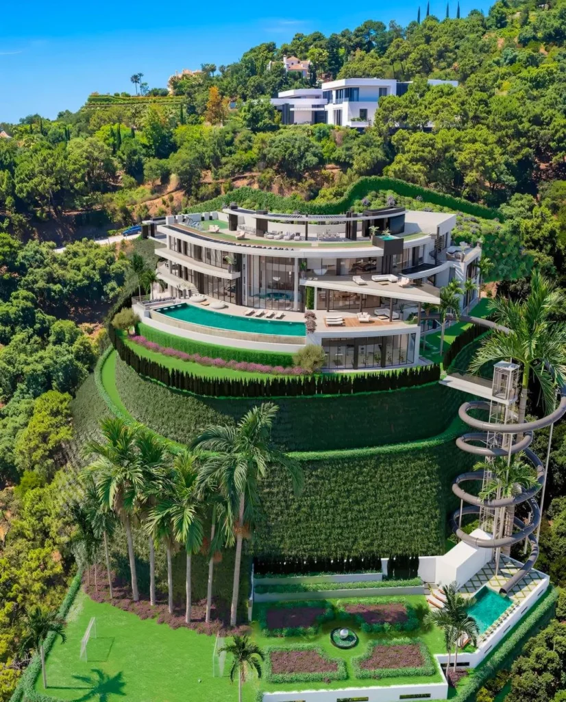 Luxury dream home exterior with hillside architecture, pool, and slide.