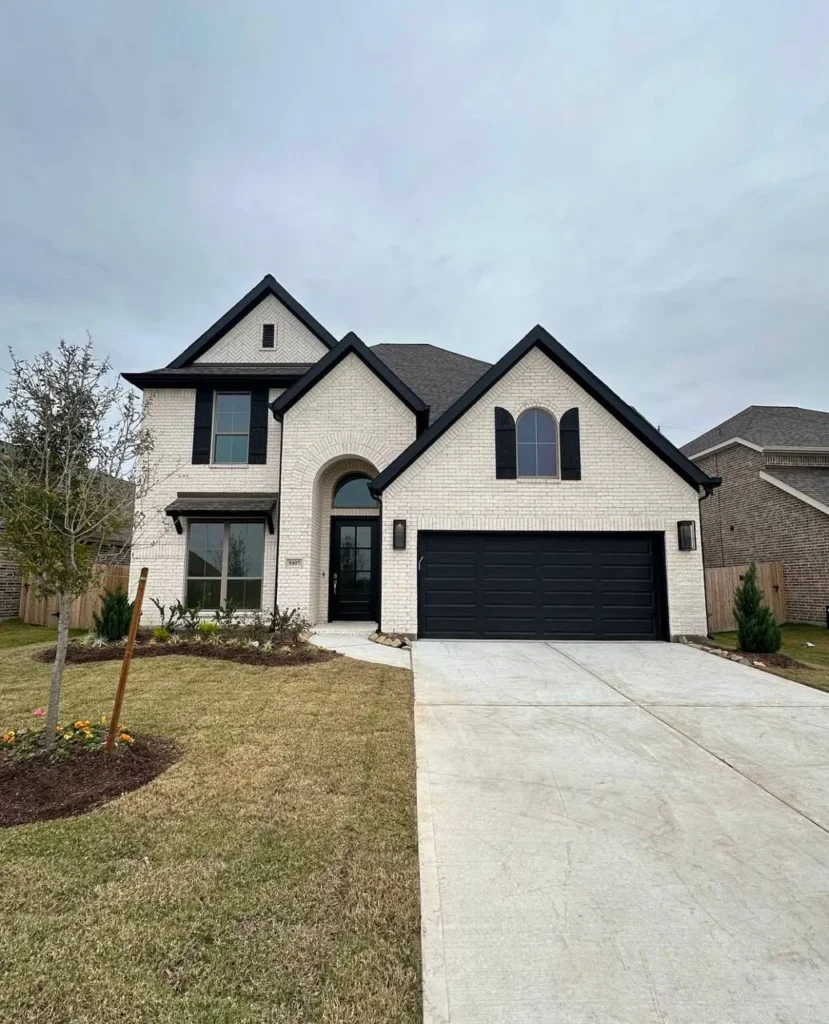 Luxury dream home exterior with whitewashed brick and dark accents.