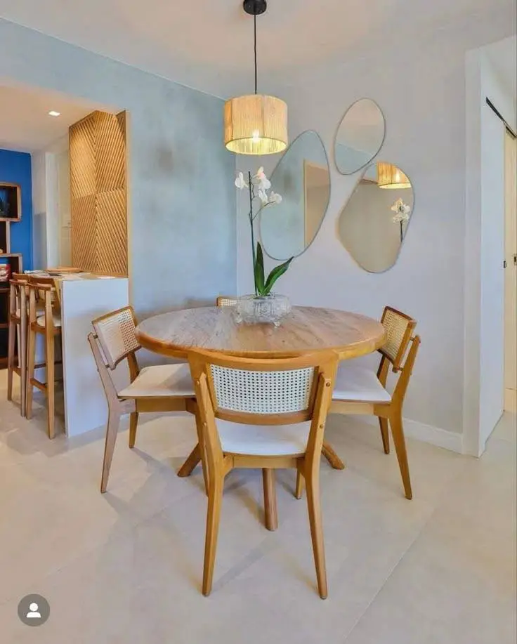 Modern dining room with round table and cane-backed chairs.