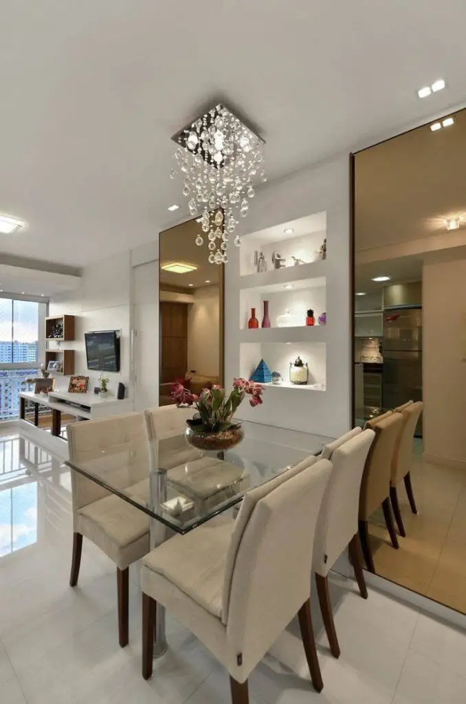 Modern dining room with large mirrored panels and crystal chandelier.