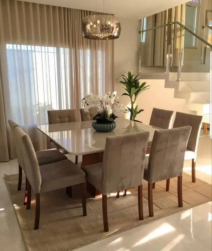 Modern dining room with large rectangular table and velvet chairs.