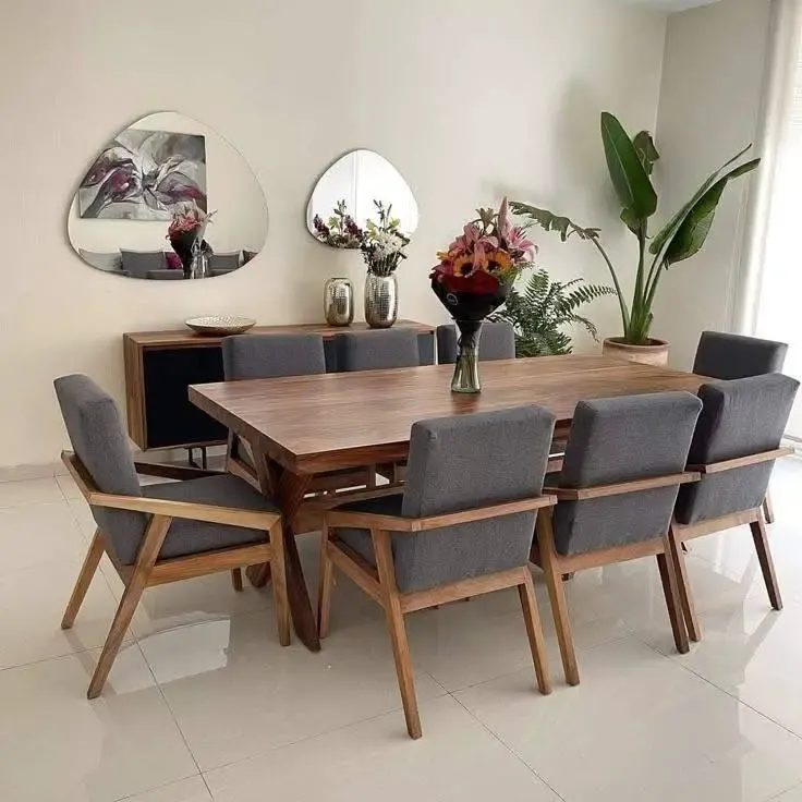 Mid-century modern dining room with wooden table and grey upholstered chairs.