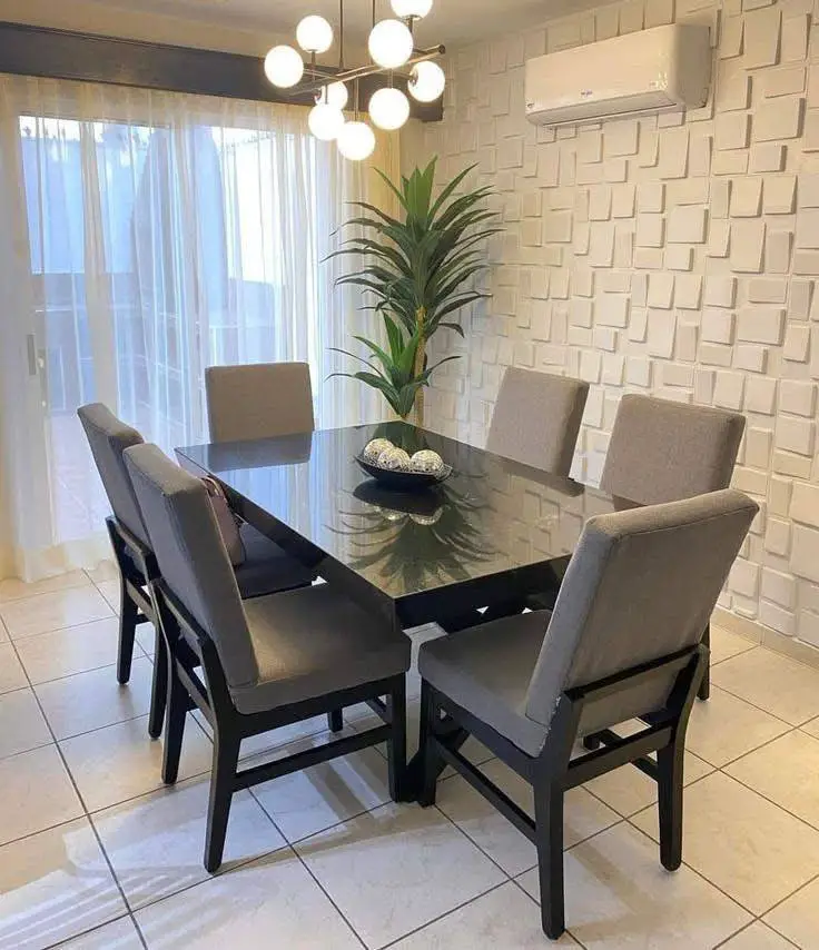 Modern dining room with textured wall and black glossy table.