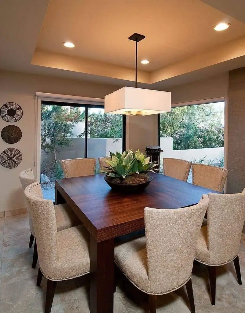 Modern dining room with large square wooden table.