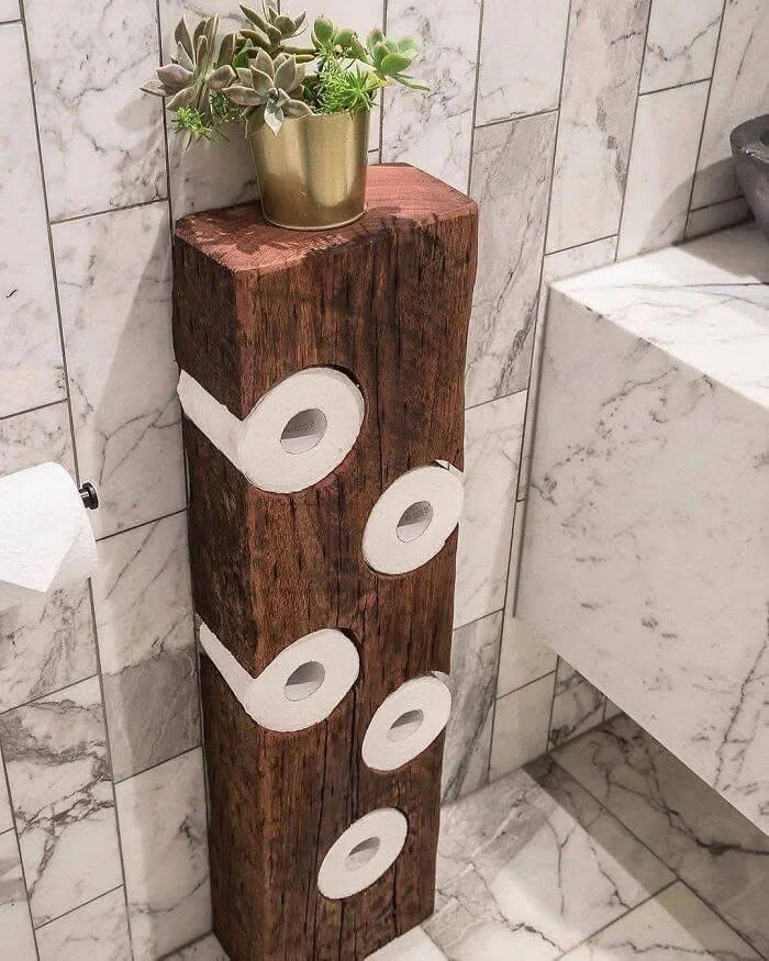 Recycled wooden log transformed into a rustic toilet paper holder.