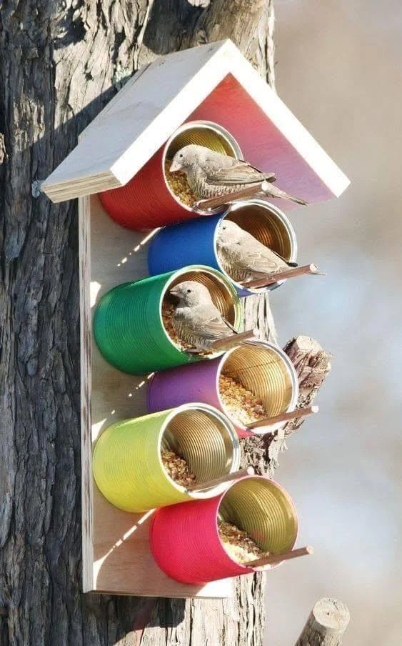 Recycled tin cans in various colors used to create a bird feeder.