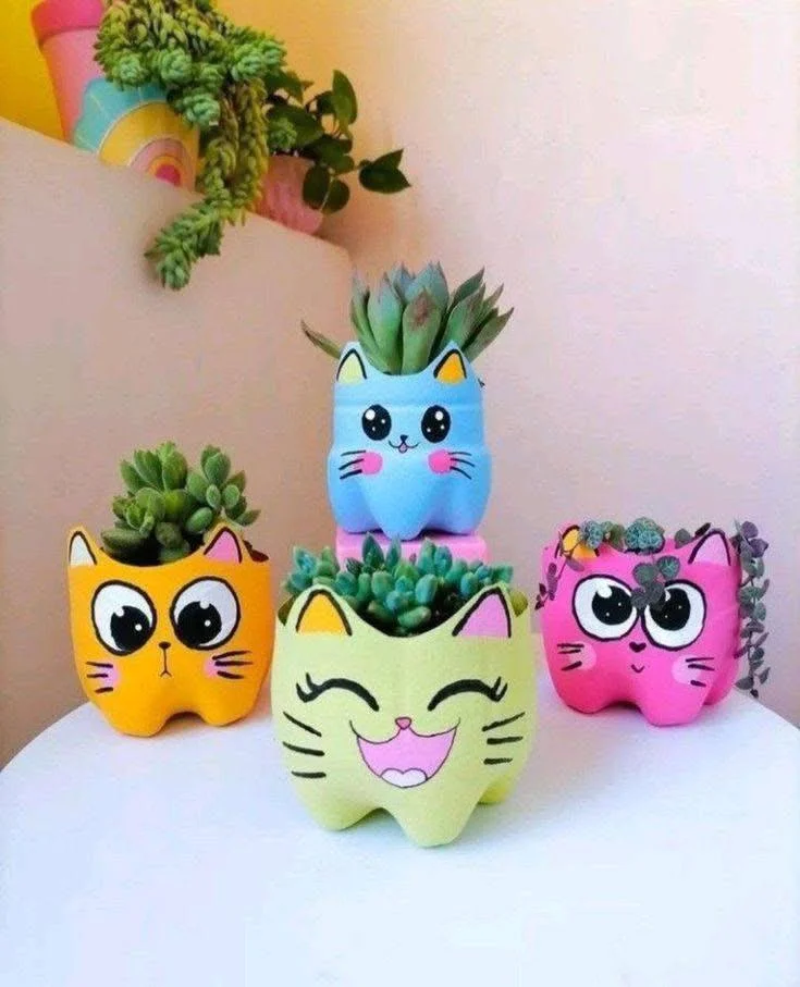 Recycled plastic bottles painted as colorful cats and used as planters.