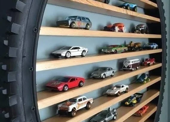 Recycled bicycle tire repurposed as a toy car display shelf.