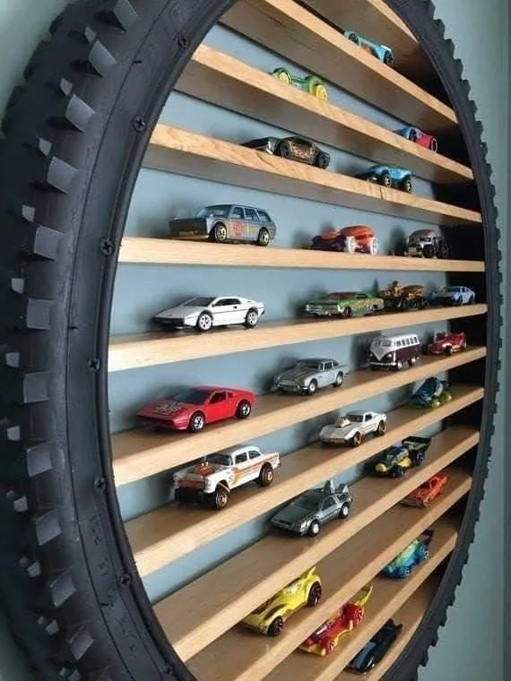 Recycled bicycle tire repurposed as a toy car display shelf.