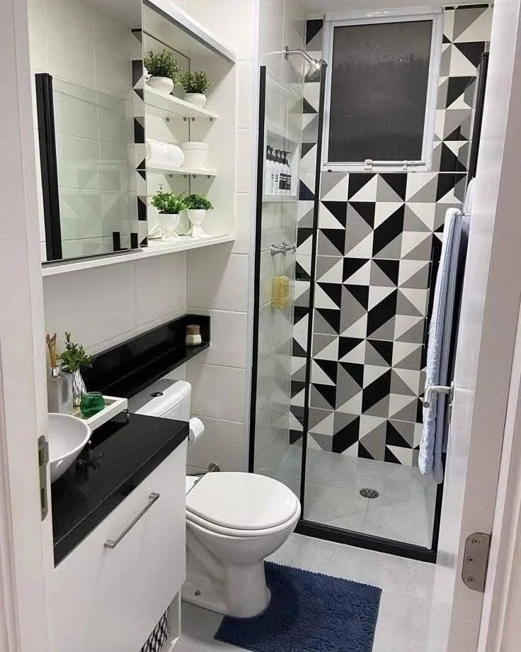 Small home organization idea featuring mirrored cabinets and open shelving in a small bathroom with geometric tiling.