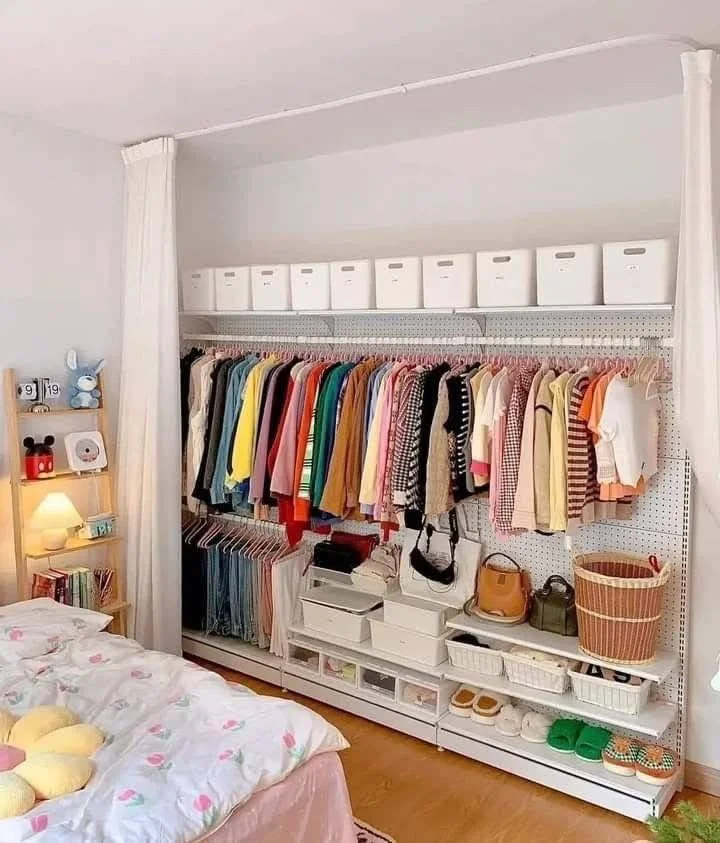 Small home organization idea featuring an open-concept wardrobe with a curtain divider.