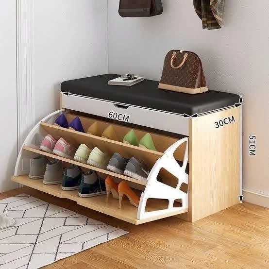 Shoe storage bench with angled shelves for organized shoe display and a padded top for seating.