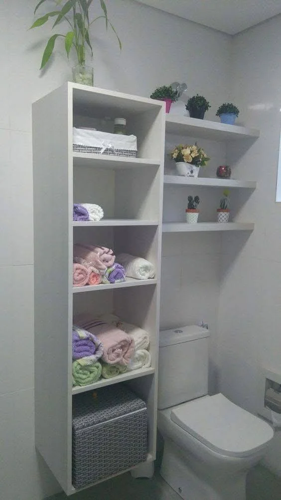 White shelving unit installed above a toilet in a bathroom, providing storage for towels and other items.