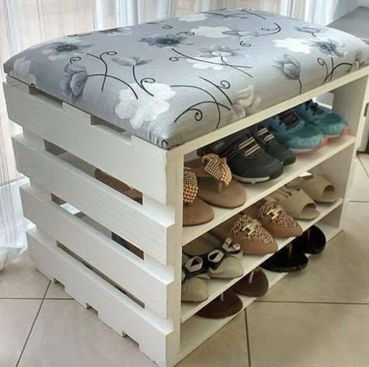 Shoe storage bench made from a repurposed wooden pallet, with a cushioned top for seating.