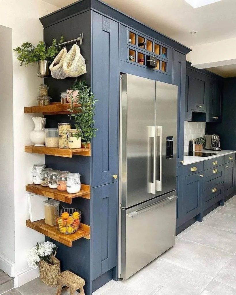 Kitchen with open wooden shelving instead of upper cabinets, displaying dishes, jars, and plants.