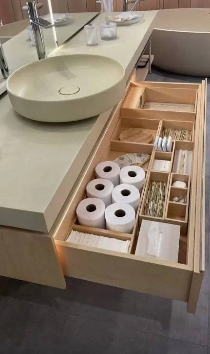 Bathroom vanity drawer with custom wooden organizers, neatly separating toiletries and supplies.