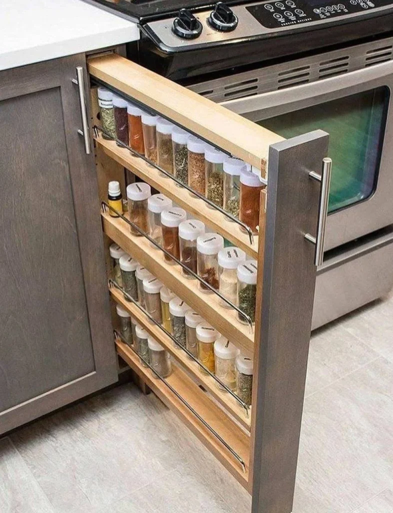 Narrow, pull-out spice rack installed in a kitchen cabinet, providing organized and accessible spice storage.