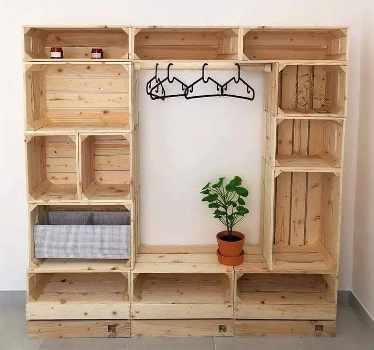 Open closet system constructed from repurposed wooden crates, providing modular storage for clothing and accessories.