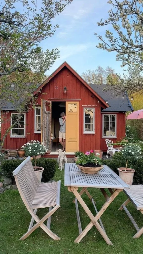 Red tiny house homestead with charming outdoor seating area.