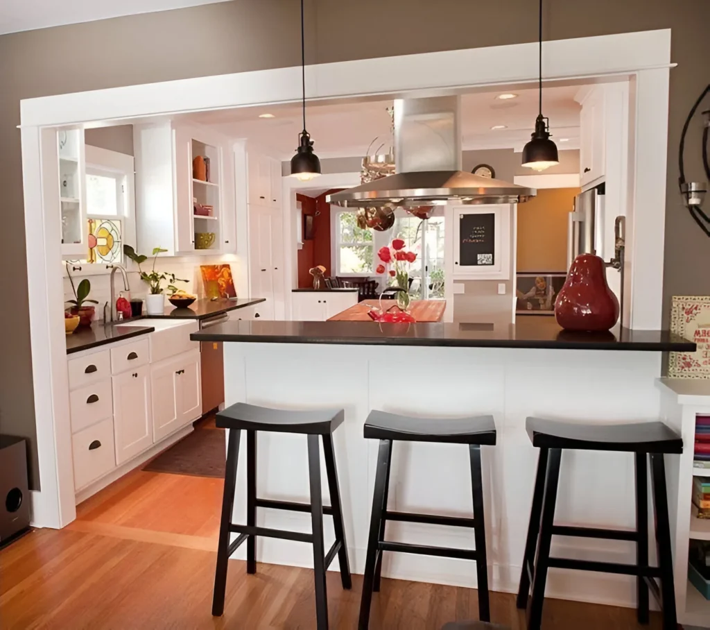 Kitchen bar with black countertop, white base, and three black stools.