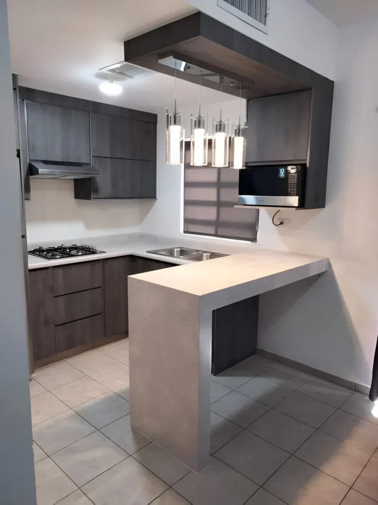 Kitchen bar with concrete-style overhang and modern pendant lighting.