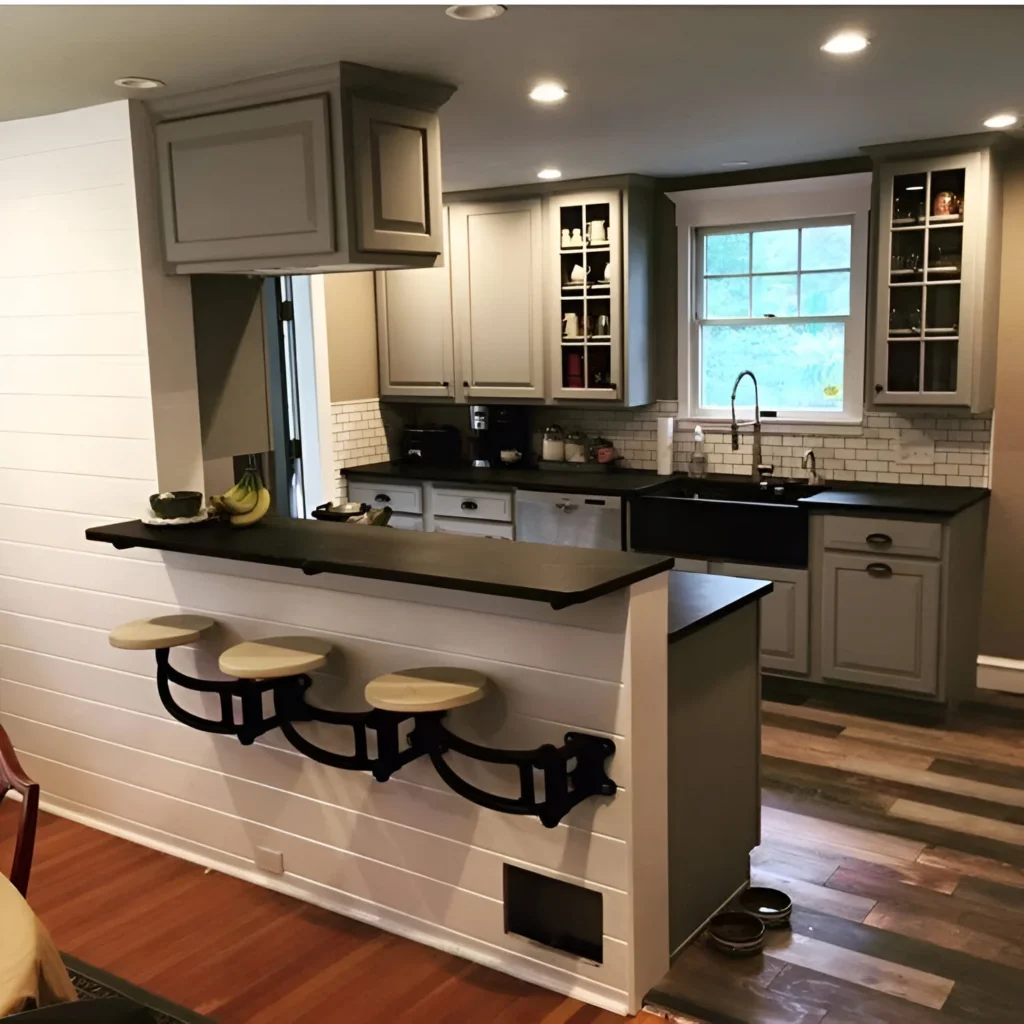 Kitchen bar with swing-out seats and dark countertop.