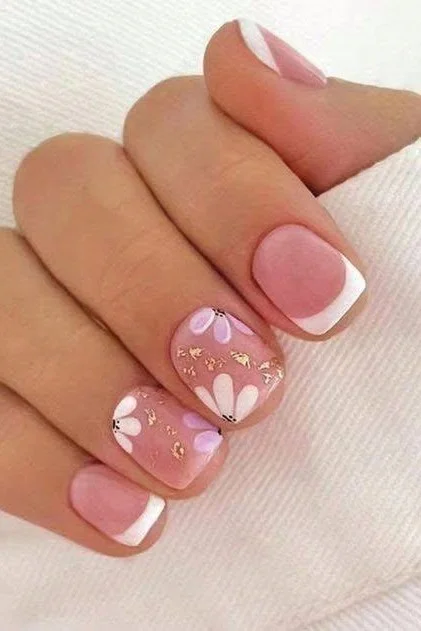 Short square press-on nails with French tips, pink and white flowers, and gold glitter.