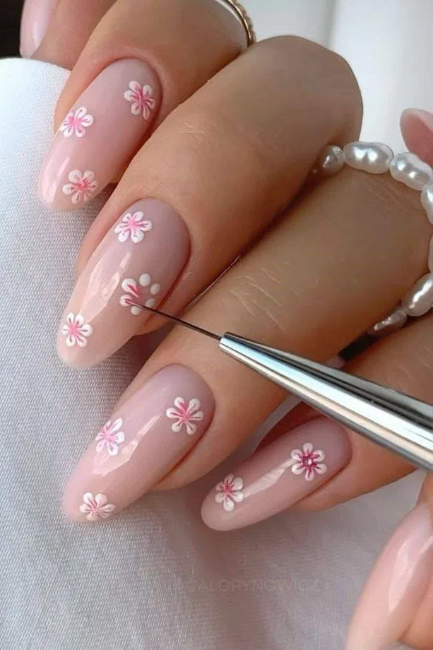 Short light pink nails with minimalist white and pink flower nail art.