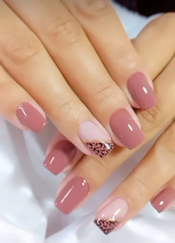 Short, muted rose-pink nails with leopard print and gold accent.