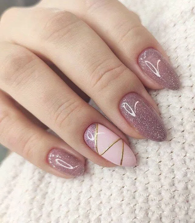 Short, glittery pink nude nails with white heart accents and gold lines.