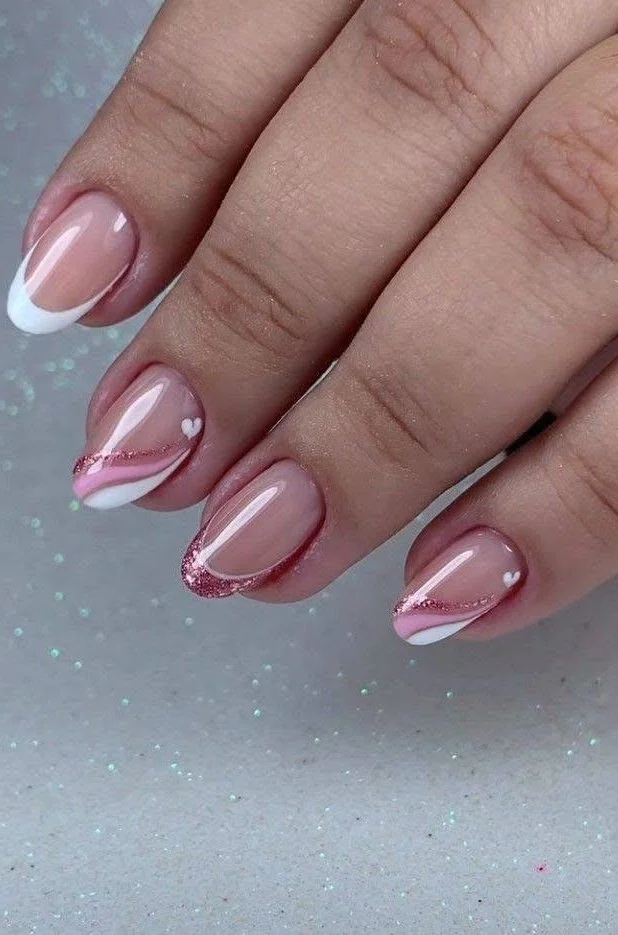 Short, sheer pink nails with white French tips, pink lines, and heart accents.