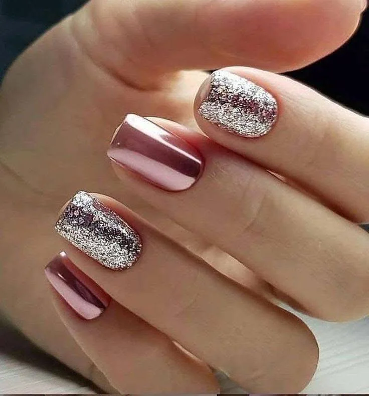 Short rose-gold chrome nails with silver-pink glitter accent nails.