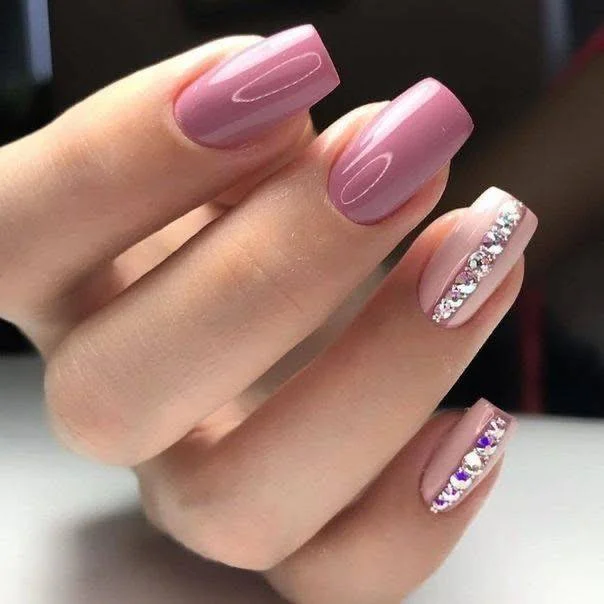 Short pink ombre nails with a vertical line of rhinestones.