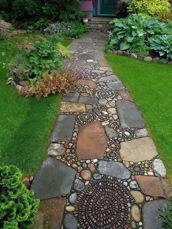 DIY garden pathway crafted with large flat stones and intricate river stone mosaic patterns.