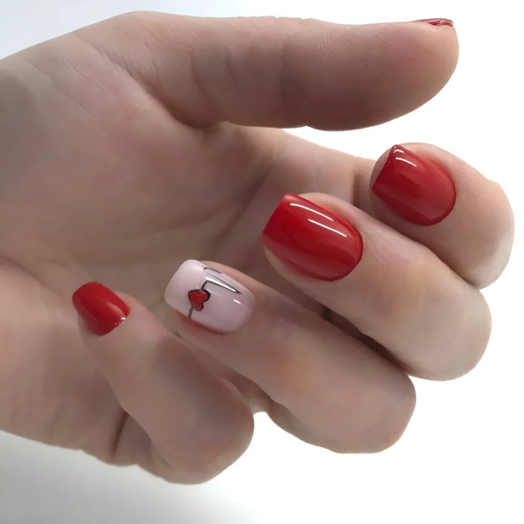 Romantic red nail design with pink heart accent, perfect for 2025 trends.