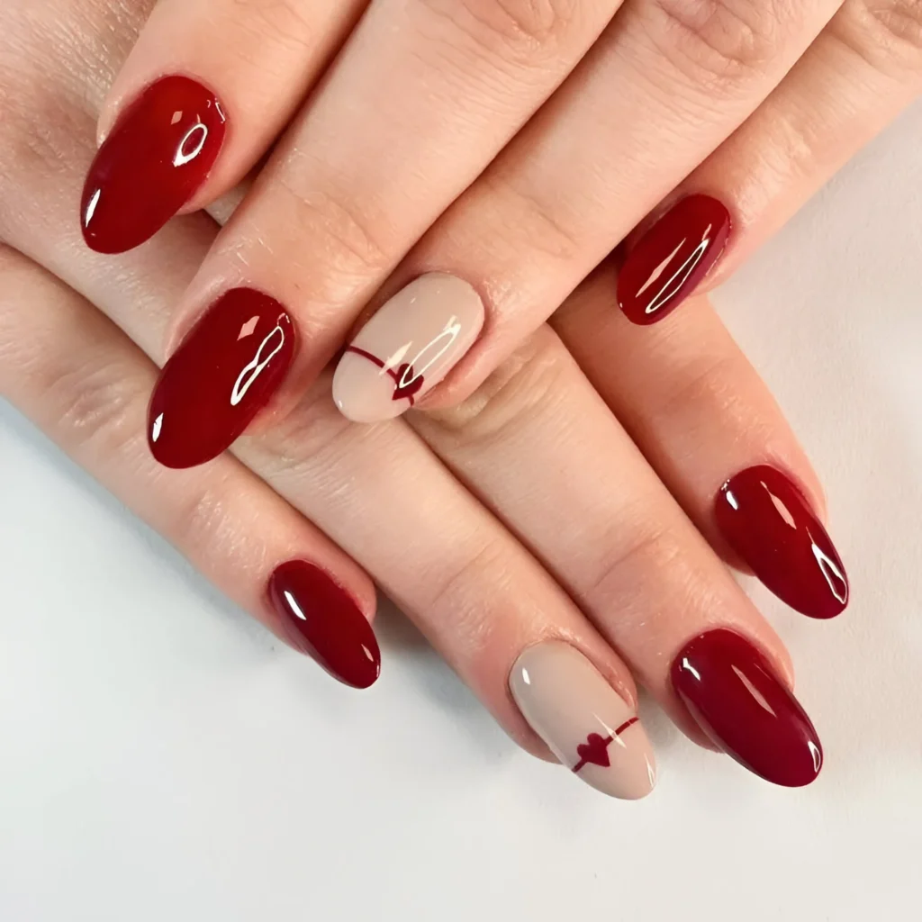 Red nails with tiny heart accent nail design.