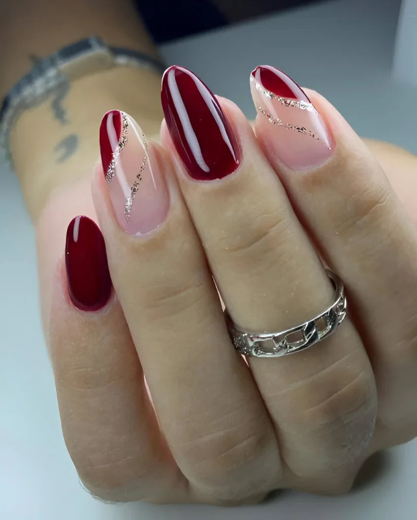 Deep red nails with silver glitter swirl design.