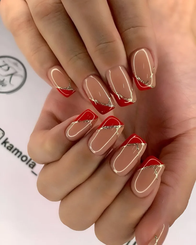 Red French tip nails with delicate gold accents.