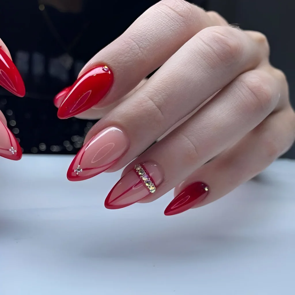 Elegant stiletto red nails with gold embellishments, a top 2025 design.