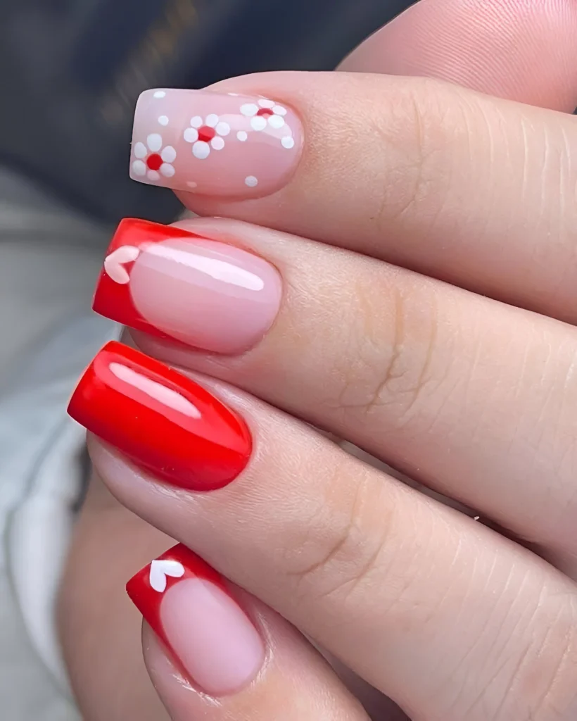 Red nails with floral and heart accents, a romantic and trendy 2025 design - Trending red nail designs