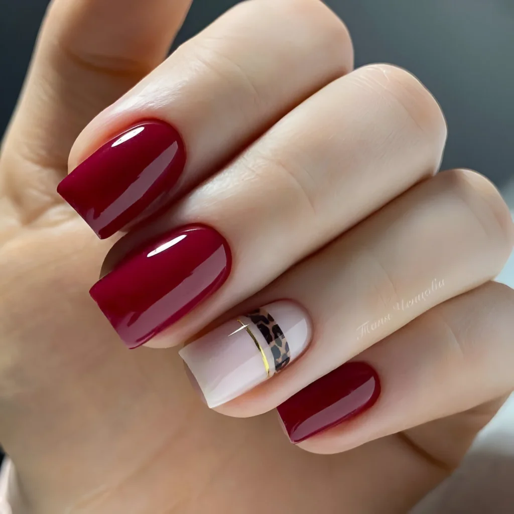 Deep red nails with leopard print accent nail.