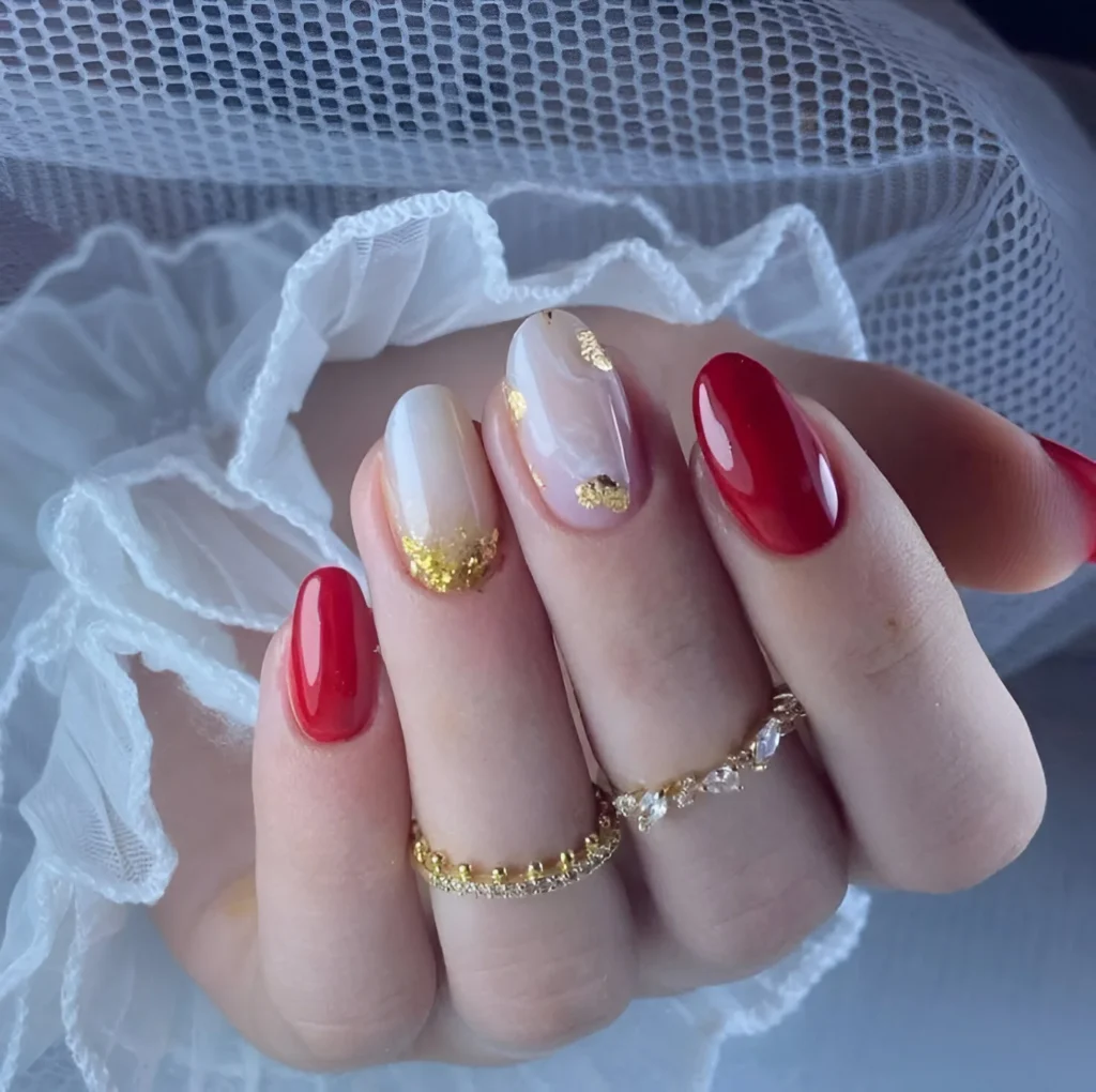 Red and gold nails with foil accents.