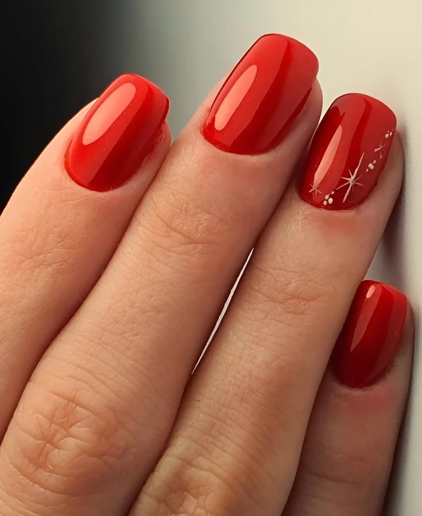 Glossy red nails with delicate white starburst accents, 2025 celestial trend