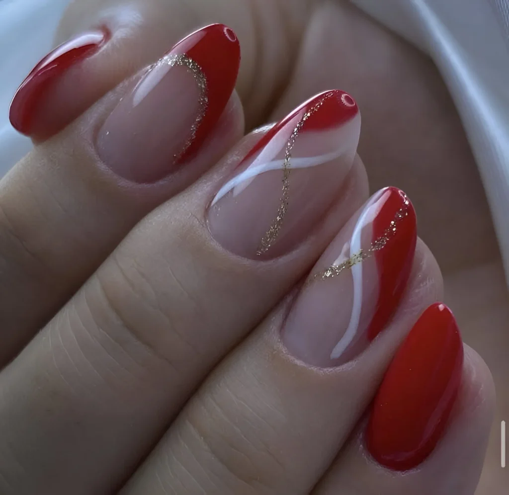 Red nails with intricate gold line art.