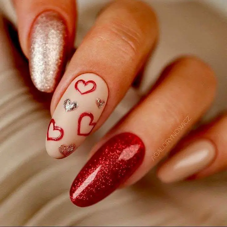 Oval nails with nude, red glitter, outlined red hearts, and silver glitter hearts.