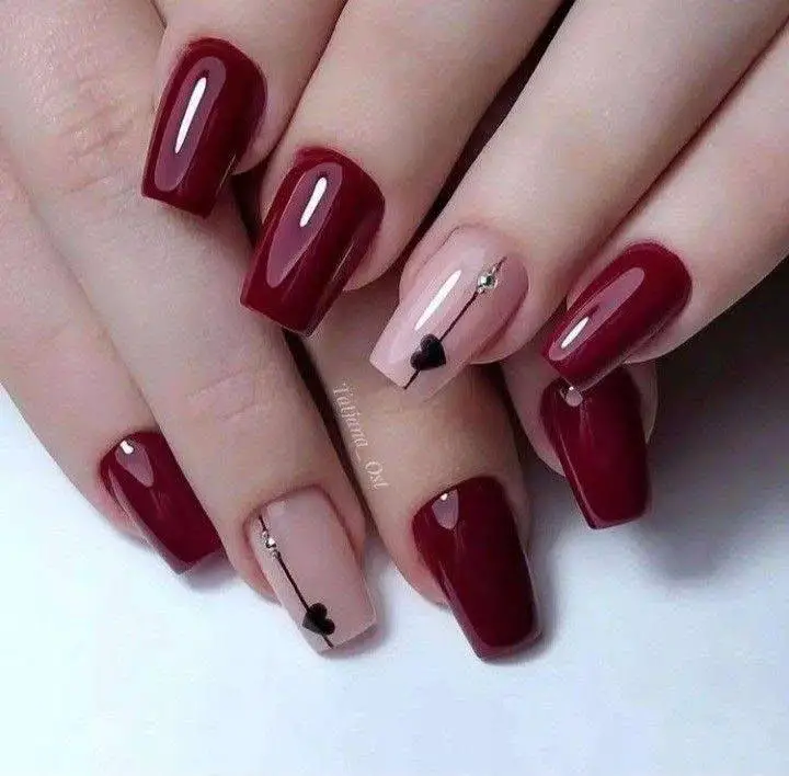 Square nails with wine-red and pale pink polish, featuring crystal and heart details.