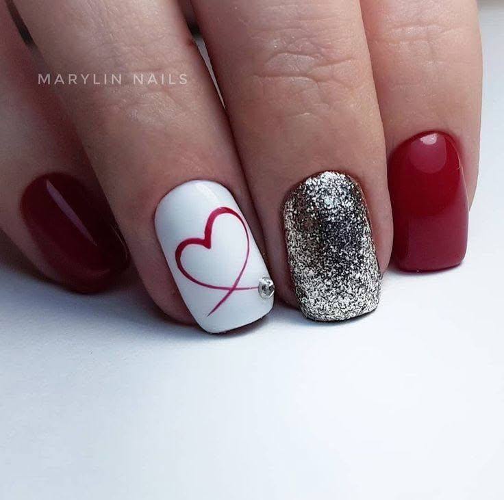 Short square nails with red, white, and silver glitter polish, featuring a red outlined heart.