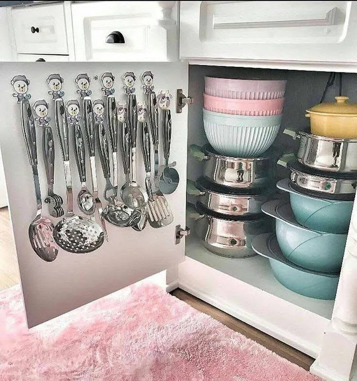 Pot lids organized vertically on a rack mounted to a kitchen cabinet door.