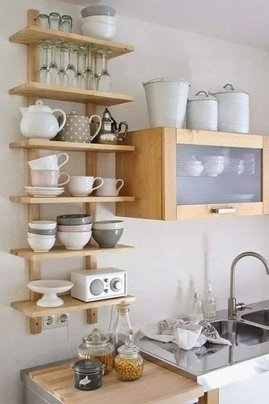 Open kitchen shelves displaying dishware, glasses, and small appliances.